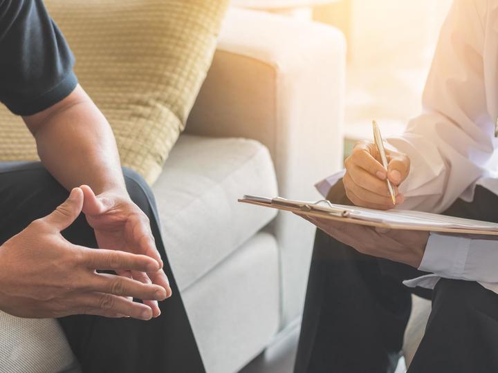 Physician with a clipboard consulting with a patient